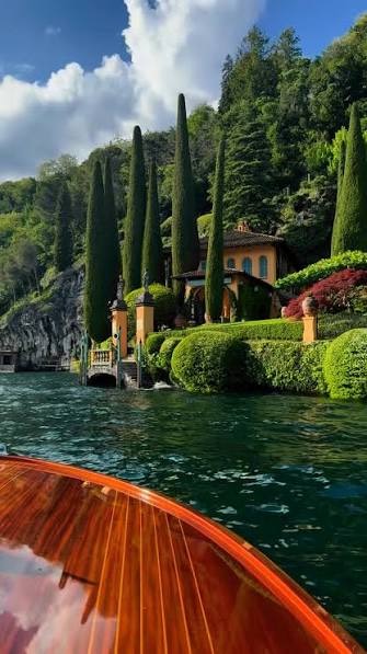 Villa gardens seen from a wooden boat on Lake Como
