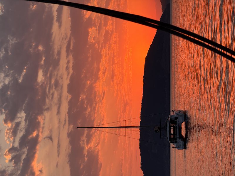 Catamaran at sunset on an orange sea