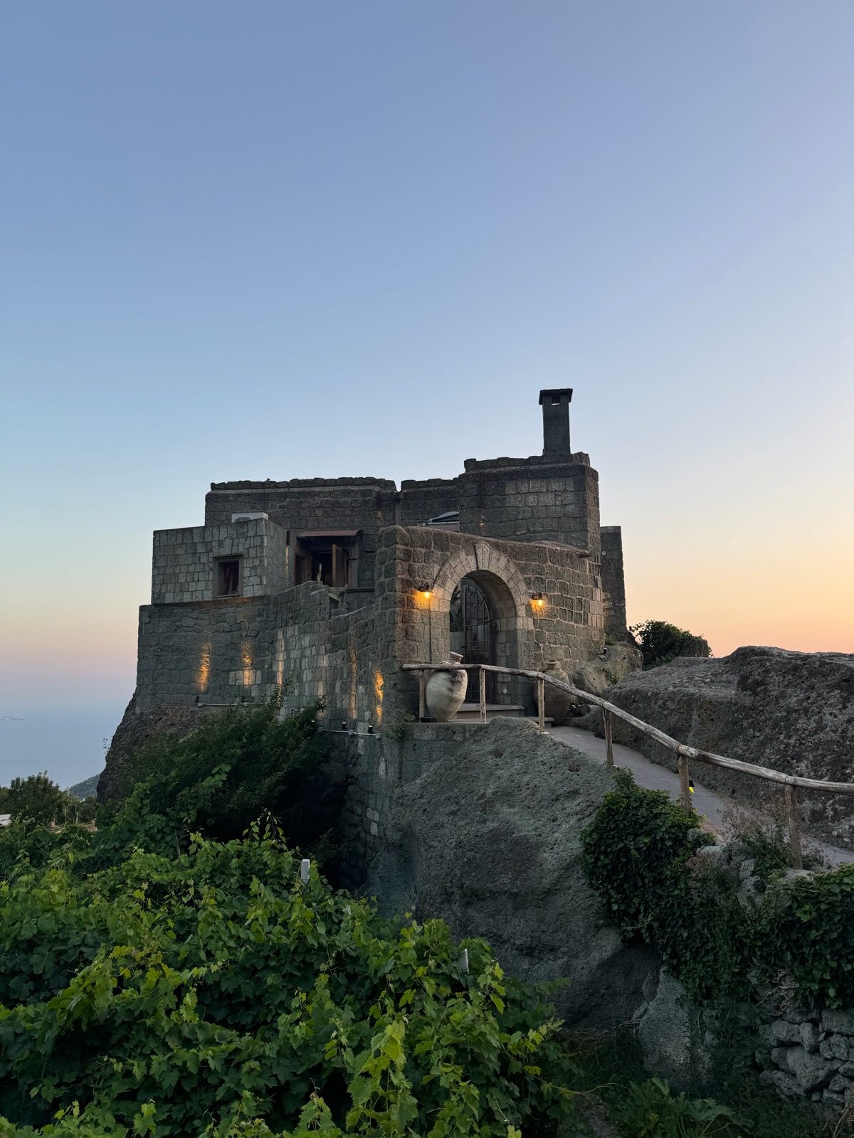 Stone tower restaurant on a rock at dusk